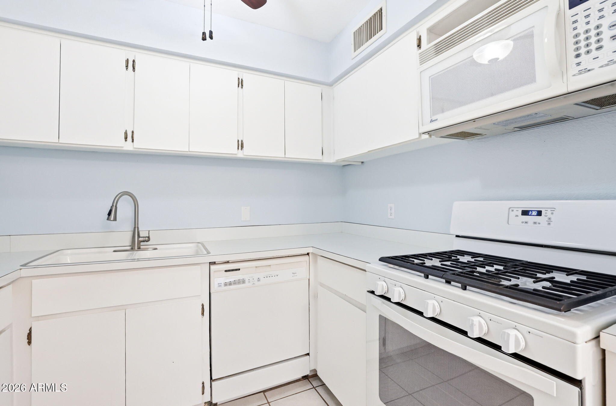 4950 North Miller Road, Unit 339 Scottsdale, AZ 85251 - Photo 17 of 28 a kitchen with white cabinets and appliances