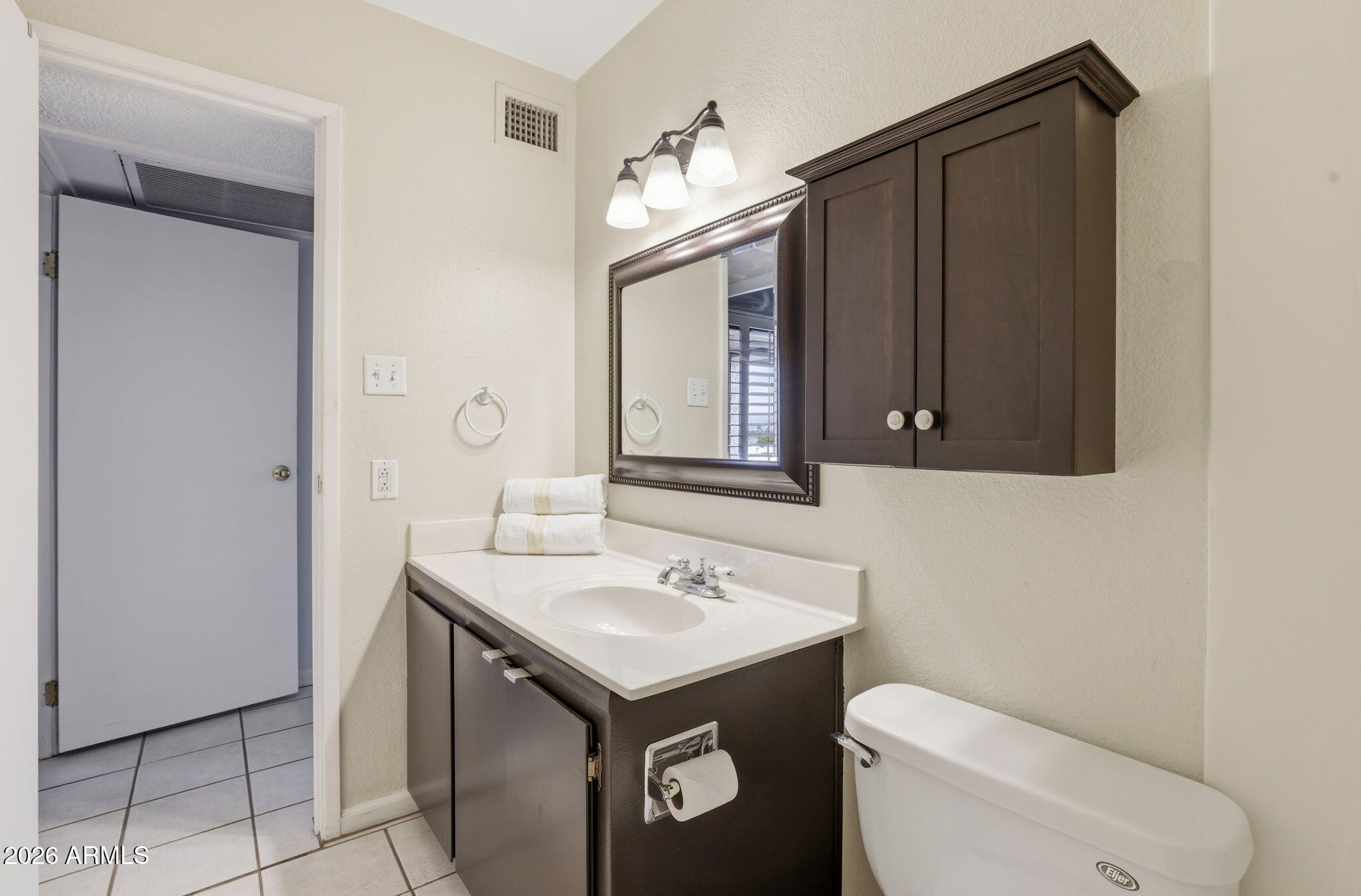 4950 North Miller Road, Unit 339 Scottsdale, AZ 85251 - Photo 20 of 28 a bathroom with a toilet sink and mirror