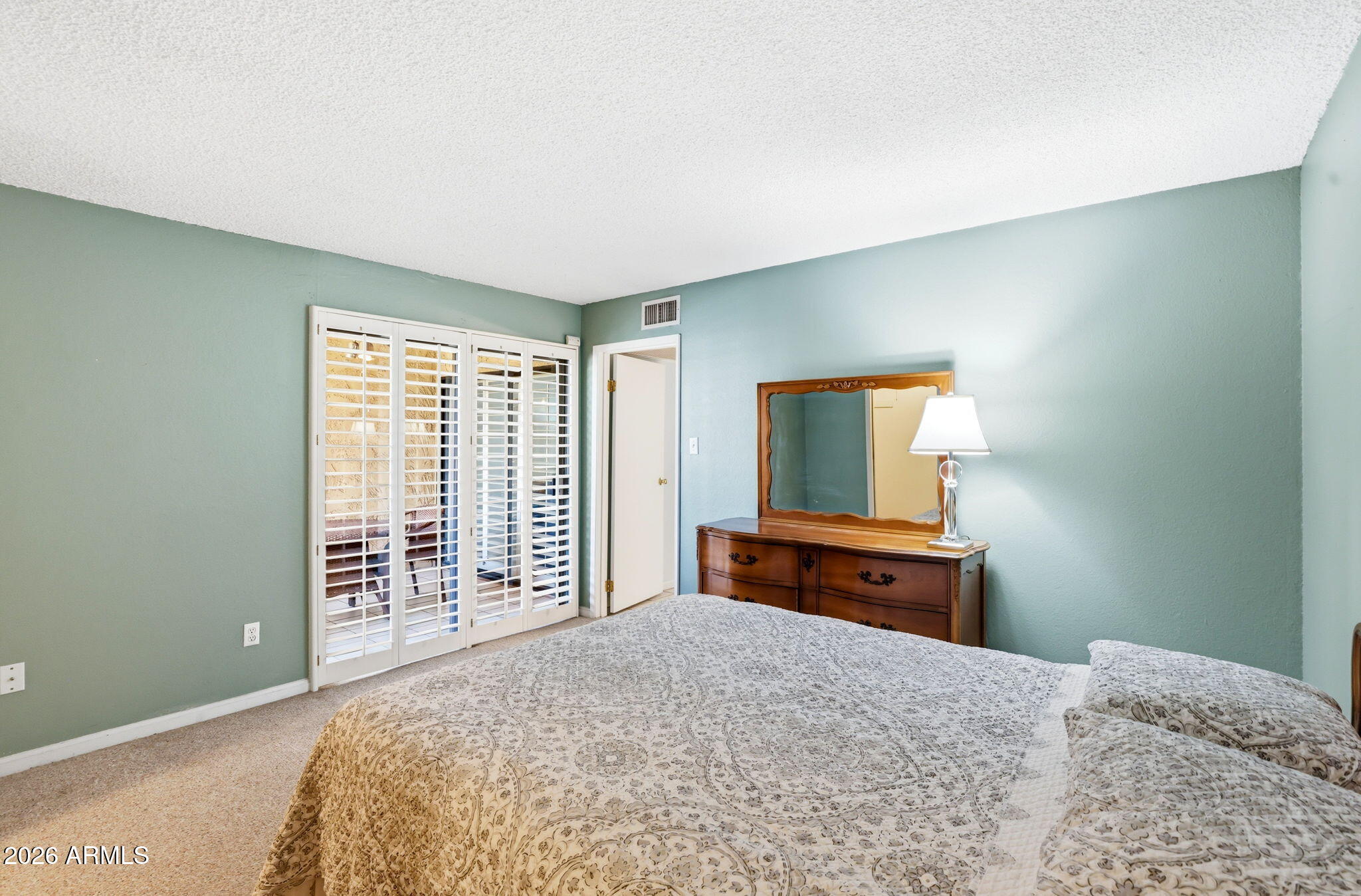 4950 North Miller Road, Unit 339 Scottsdale, AZ 85251 - Photo 22 of 28 a bedroom with a bed and a dresser with mirror