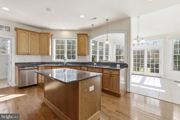 a kitchen with granite countertop wooden cabinets stainless steel appliances and a counter space