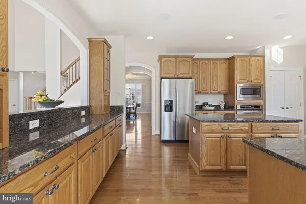 a kitchen with granite countertop a sink window and cabinets