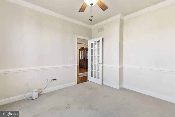 an empty room with closet and a ceiling fan