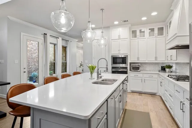 a kitchen with stainless steel appliances kitchen island granite countertop a stove a sink and a refrigerator