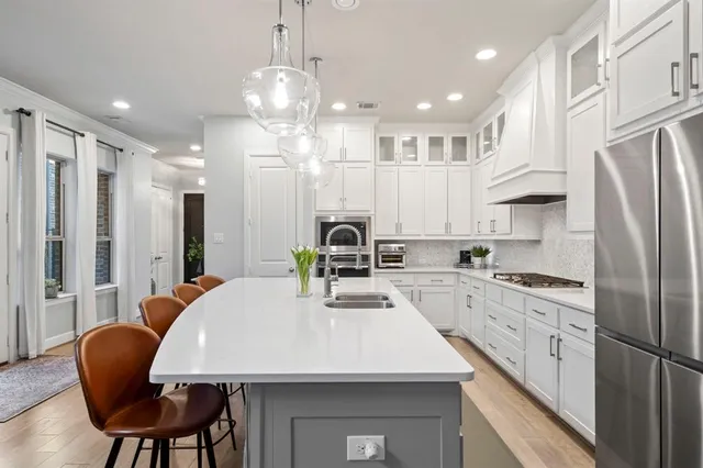 a kitchen with stainless steel appliances granite countertop a sink refrigerator and cabinets