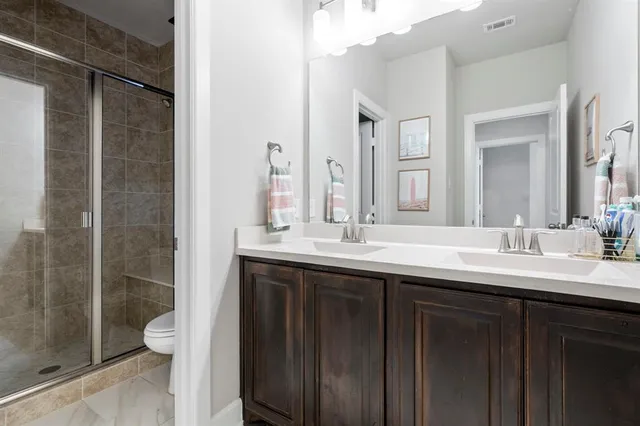 a bathroom with a double vanity sink mirror and toilet