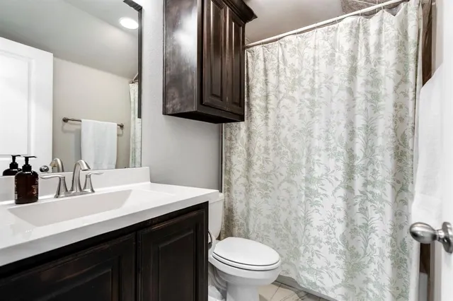 a bathroom with a double vanity sink toilet and a mirror