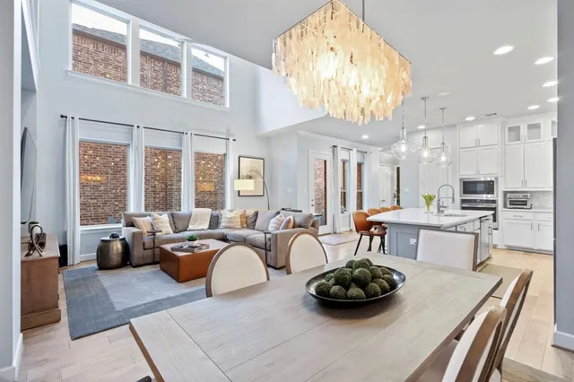 a large living room with furniture a chandelier and a large window