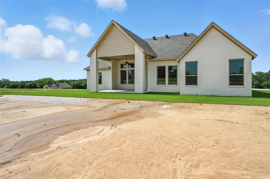 224 Kilkenny Road Poolville, TX 76487 - Photo 29 of 32 a front view of a house with a yard and garage