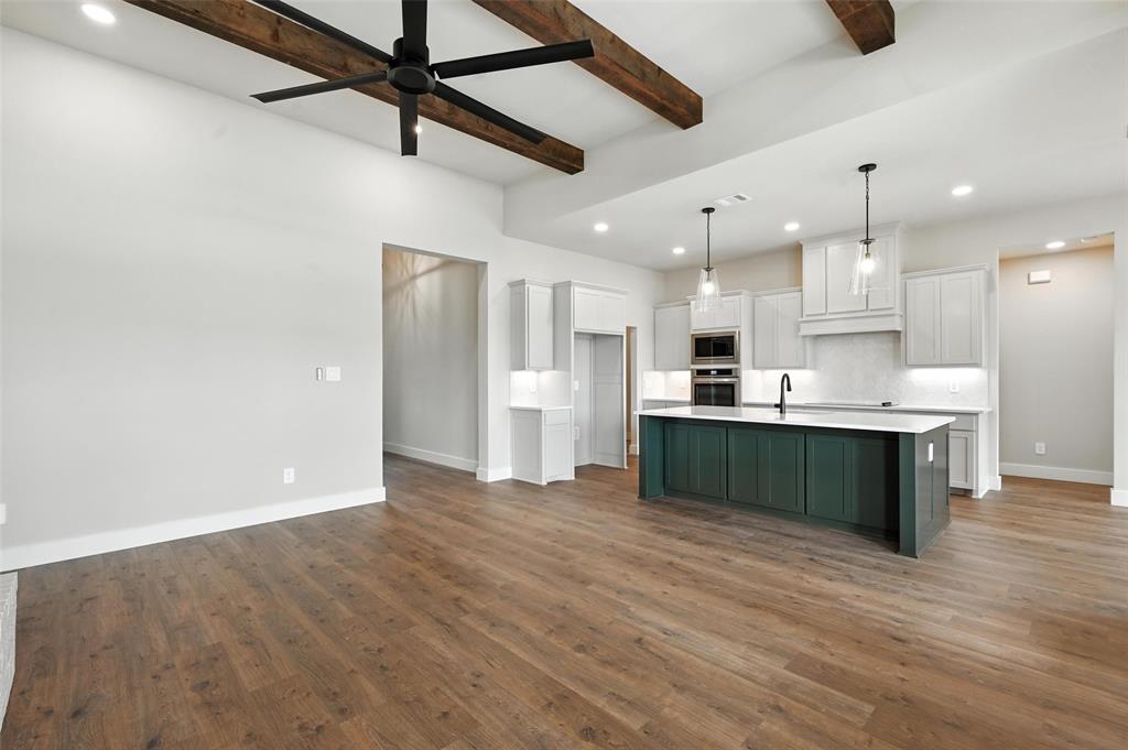 224 Kilkenny Road Poolville, TX 76487 - Photo 6 of 32 a view of kitchen with kitchen island a refrigerator wooden floor and a counter top space