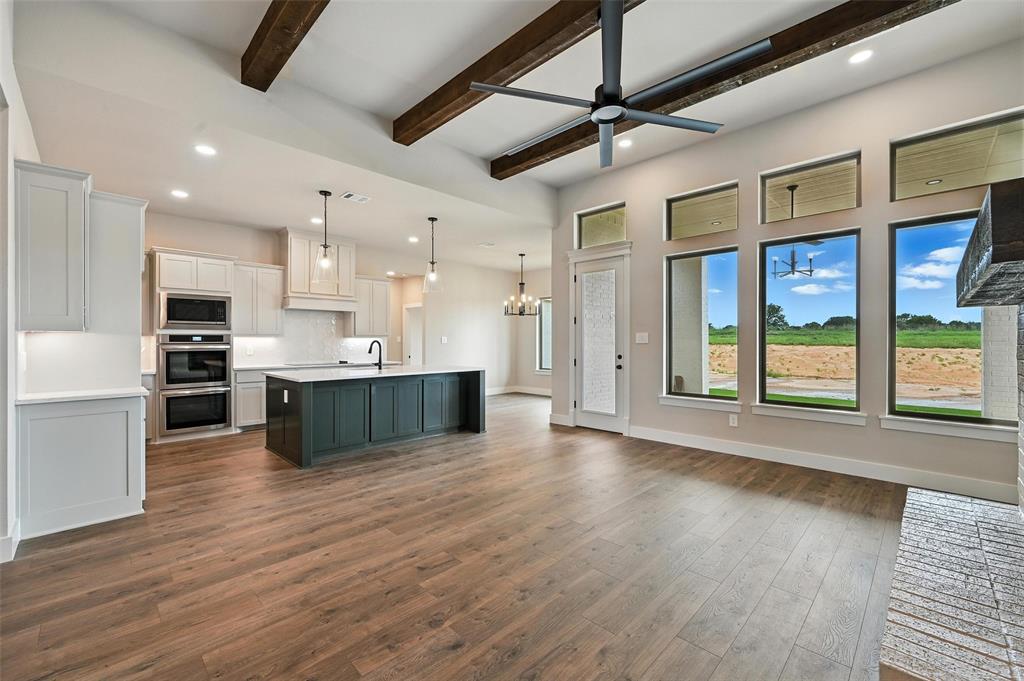 224 Kilkenny Road Poolville, TX 76487 - Photo 7 of 32 a large kitchen with stainless steel appliances kitchen island a large counter top and a wooden floors