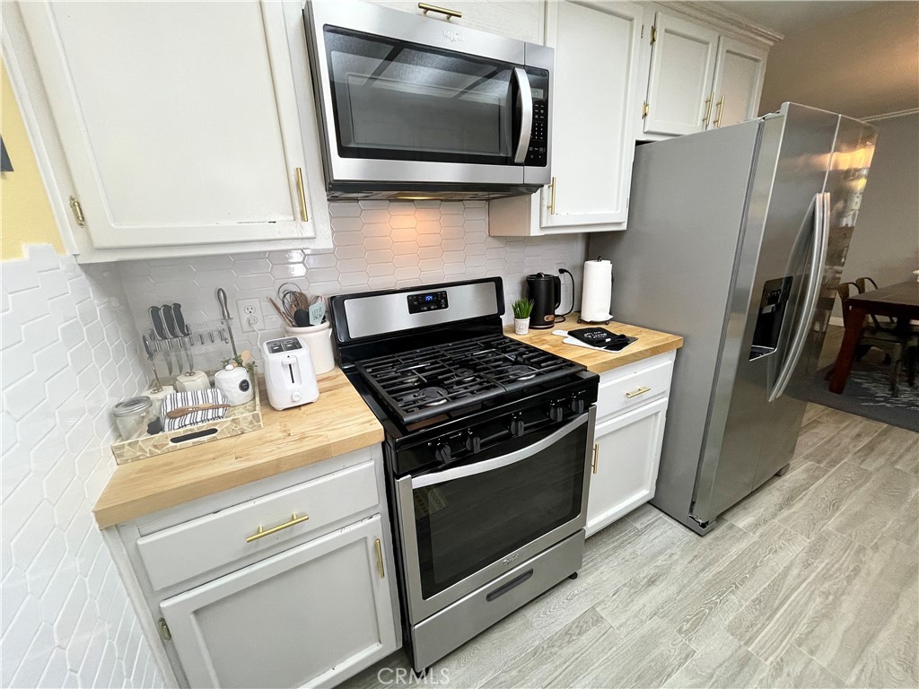 3332 Shamrock Avenue Merced, CA 95340 - Photo 12 of 35 a kitchen with stainless steel appliances a stove a microwave a sink and cabinets