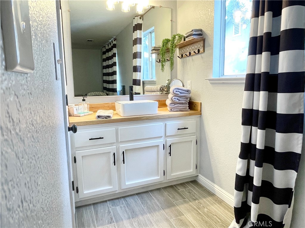3332 Shamrock Avenue Merced, CA 95340 - Photo 26 of 35 a bathroom with a sink a mirror a vanity and a shower