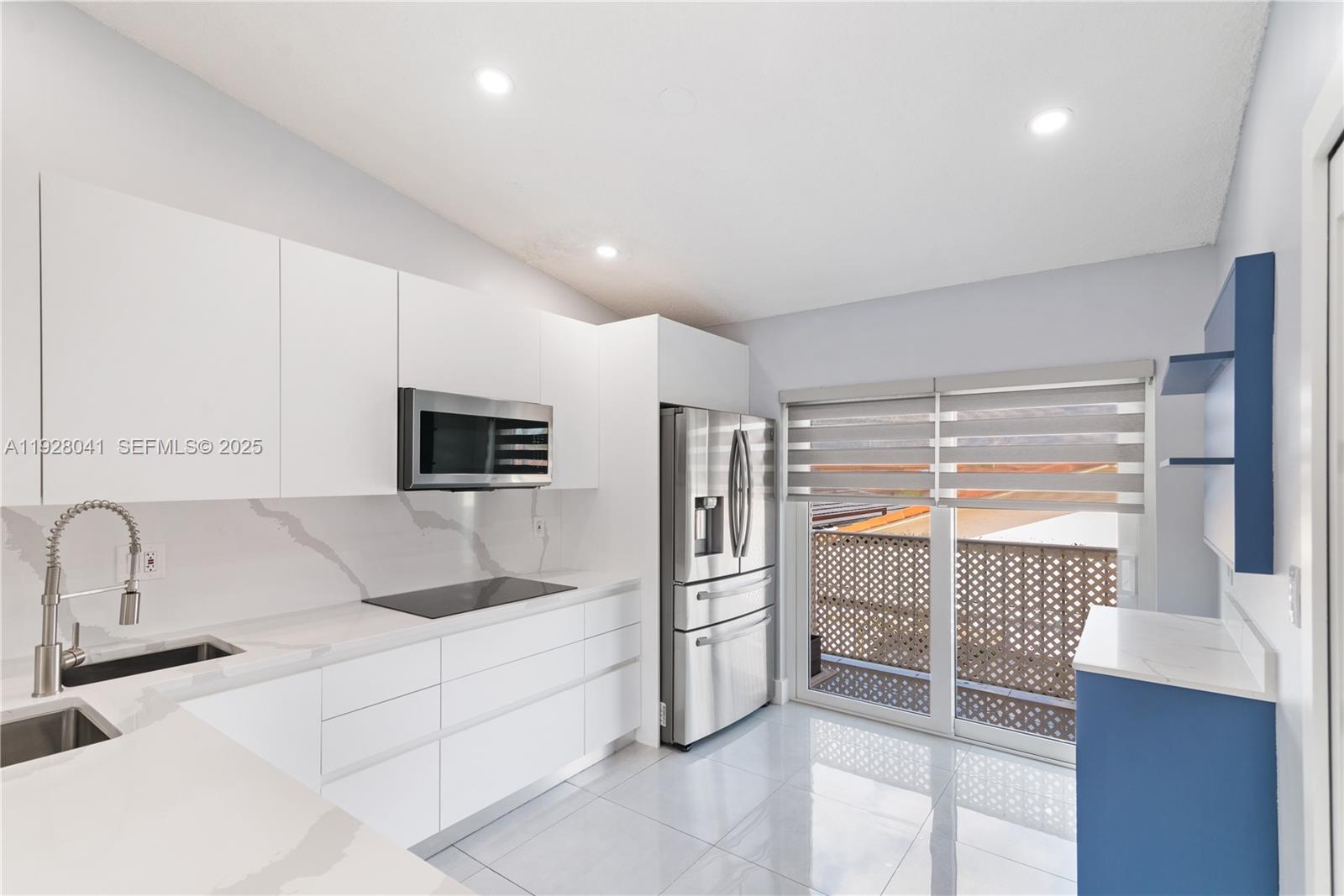 3375 West 76th Street, Unit 210 Hialeah, FL 33018 - Photo 11 of 31 a kitchen with white cabinets and a sink