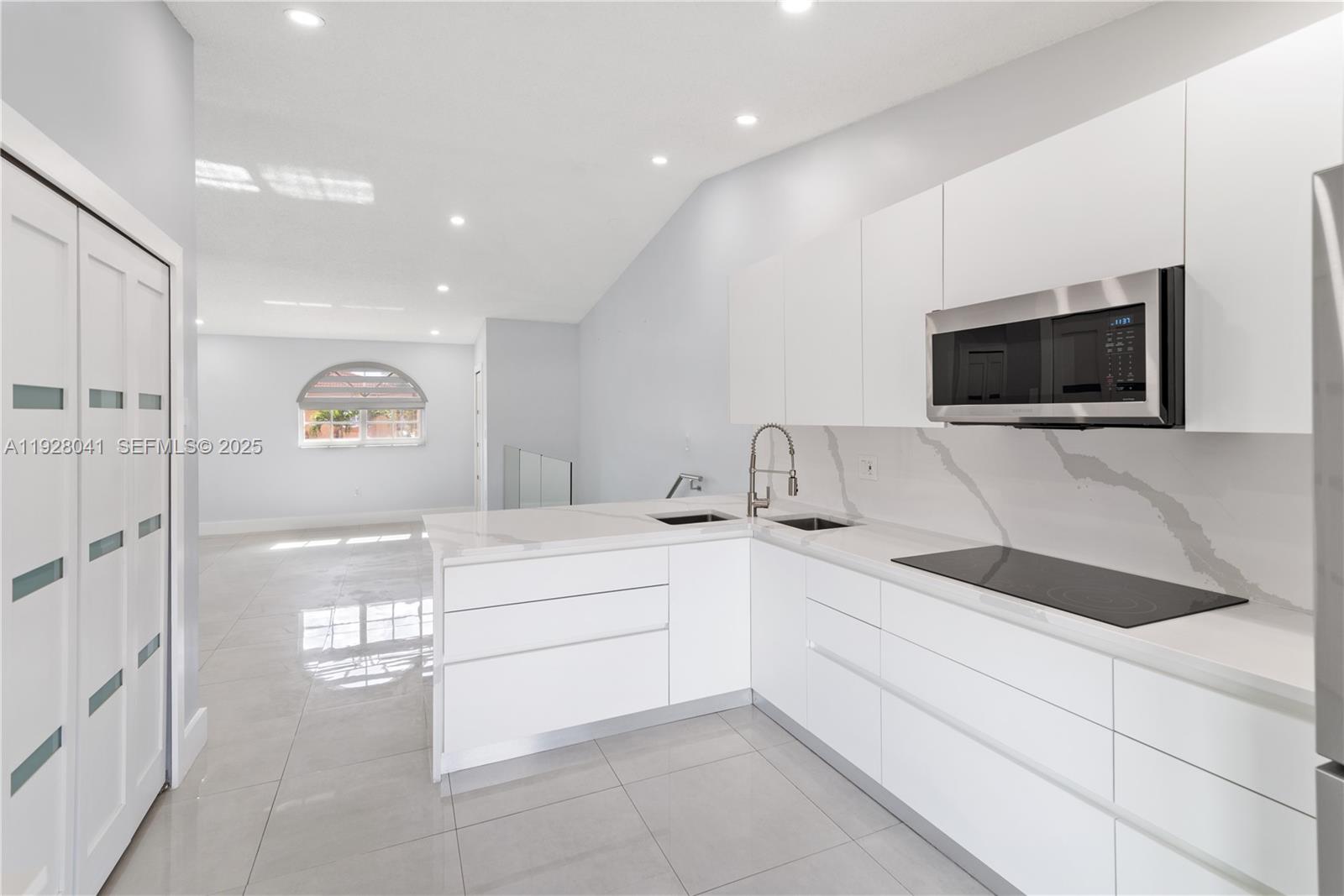 3375 West 76th Street, Unit 210 Hialeah, FL 33018 - Photo 14 of 31 a kitchen with a sink and a flat screen tv