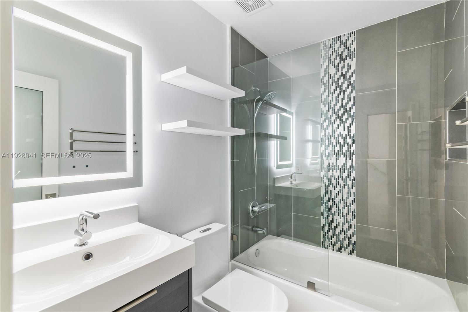 3375 West 76th Street, Unit 210 Hialeah, FL 33018 - Photo 23 of 31 a bathroom with a bathtub shower sink vanity and a toilet