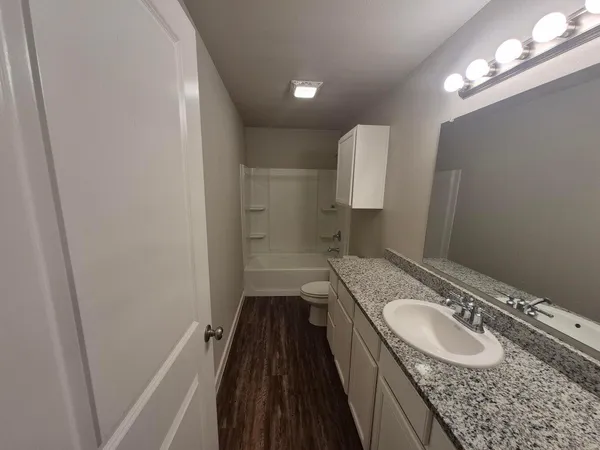 a bathroom with a granite countertop sink a mirror and vanity