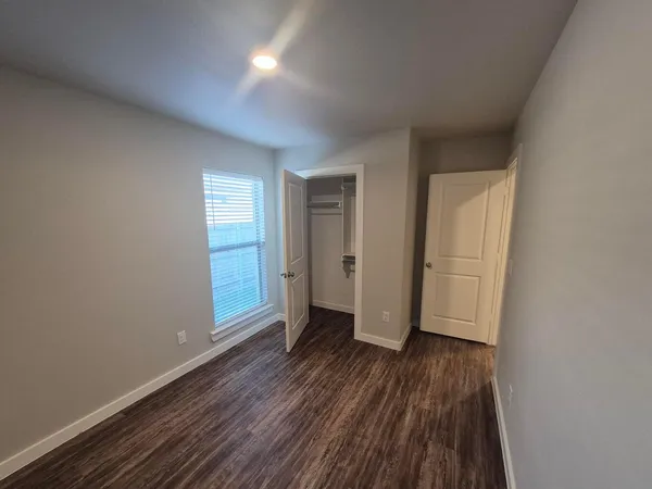 a view of a room with wooden floor and window
