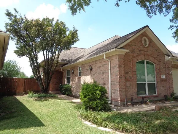 a view of a brick house with a large windows and a yard