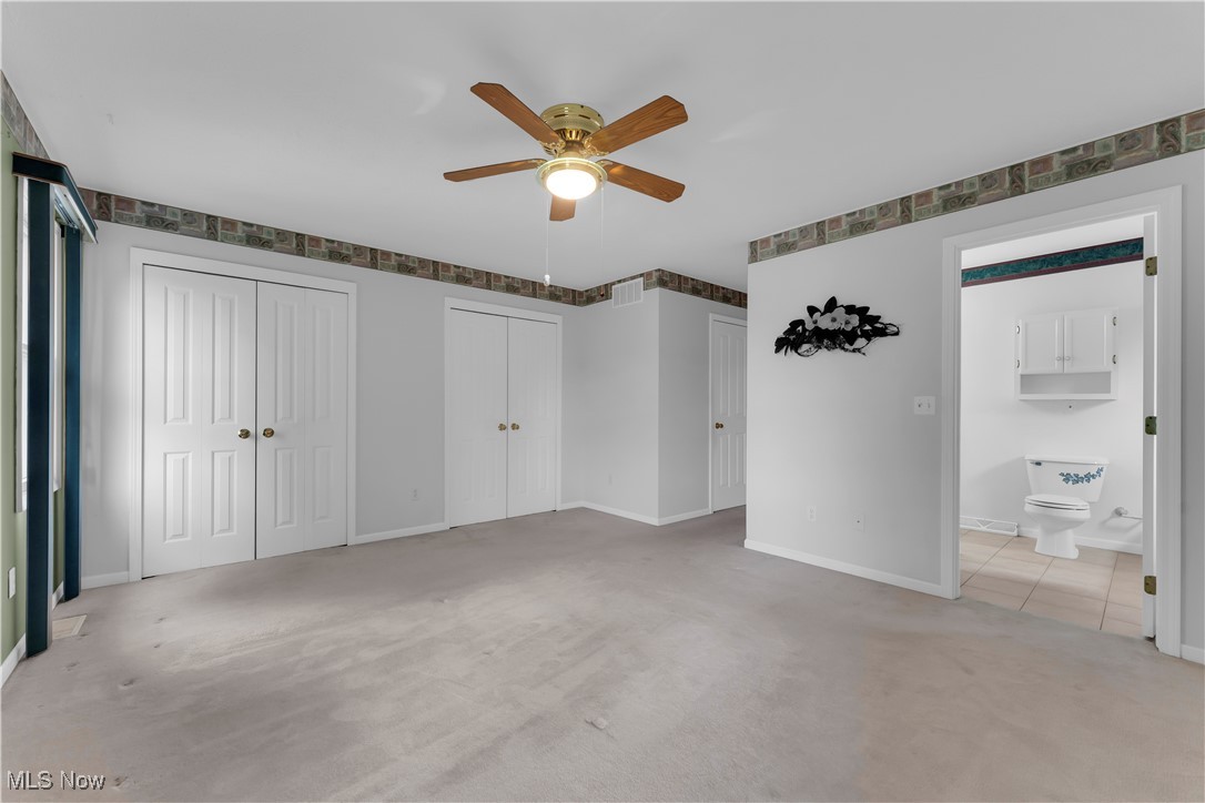 8651 State Road North Royalton, OH 44133 - Photo 20 of 33 Unfurnished bedroom featuring light colored carpet, two closets, and a ceiling fan