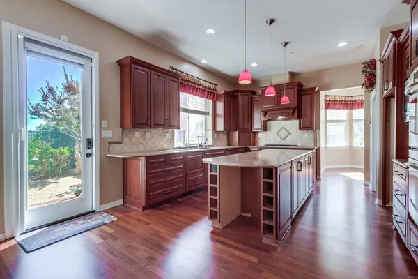 a kitchen with granite countertop wooden cabinets a sink and a window
