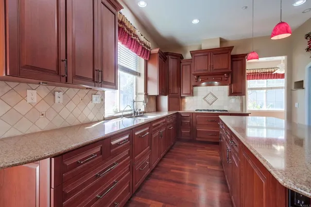 a kitchen with stainless steel appliances granite countertop a kitchen island a stove and a refrigerator