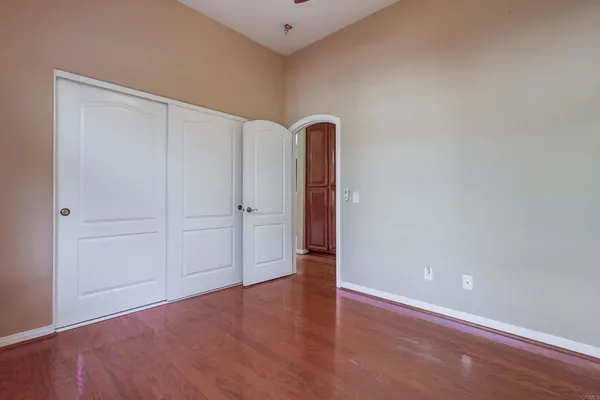 an empty room with windows and chandelier fan