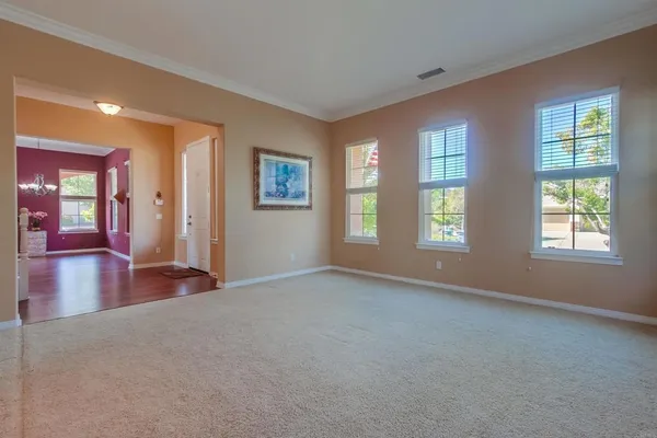 a kitchen with stainless steel appliances granite countertop a stove a refrigerator a sink and a dining table with wooden floor