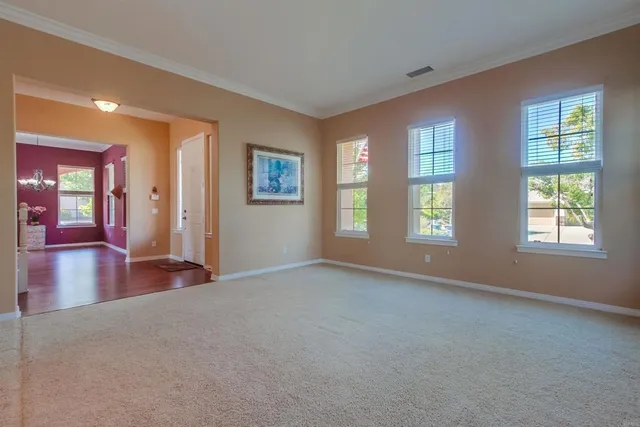 a kitchen with stainless steel appliances granite countertop a stove a refrigerator a sink and a dining table with wooden floor