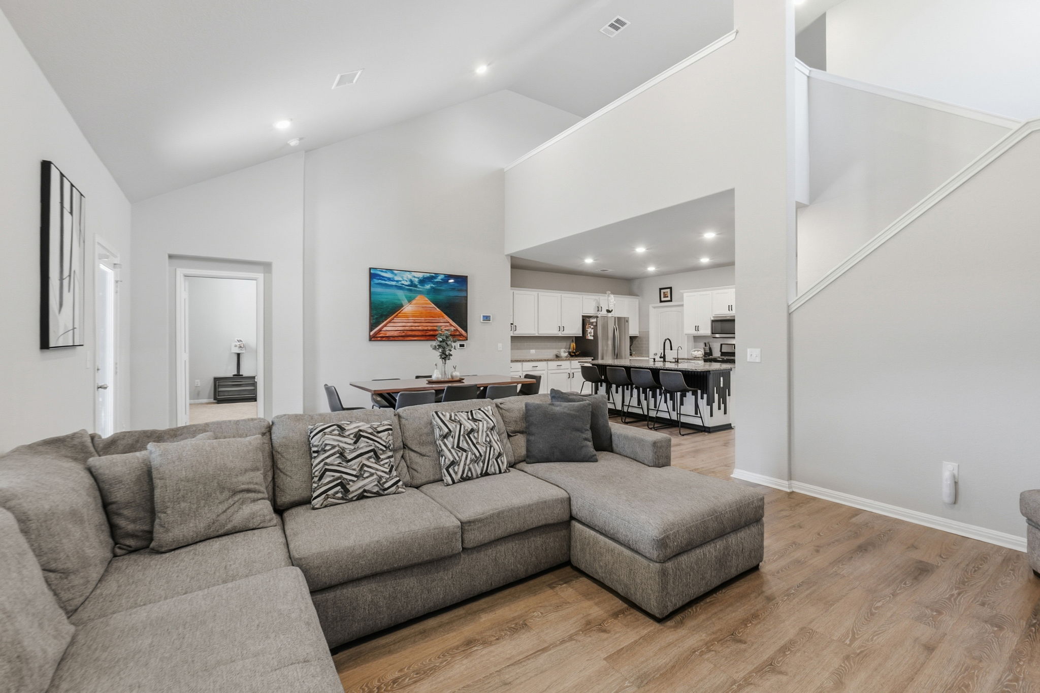 142 Brunnen Way Georgetown, TX 78626 - Photo 9 of 22 An airy living area with soaring vaulted ceilings offers seamless transitions to dining and kitchen spaces.