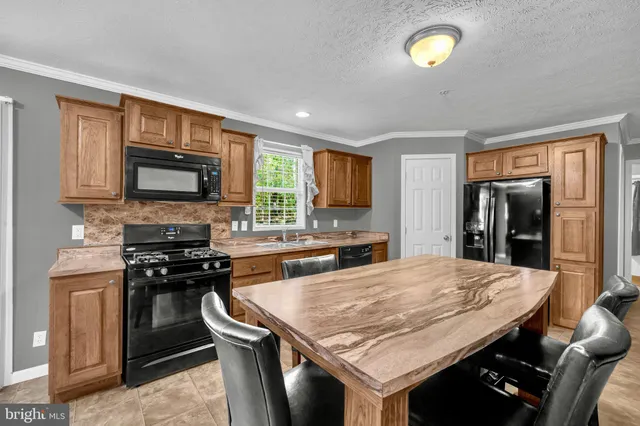 a kitchen with stainless steel appliances granite countertop wooden cabinets and stove top oven