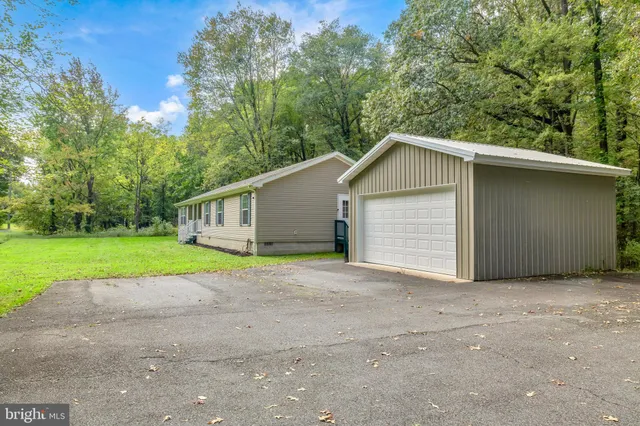 a view of a house with a yard and large trees