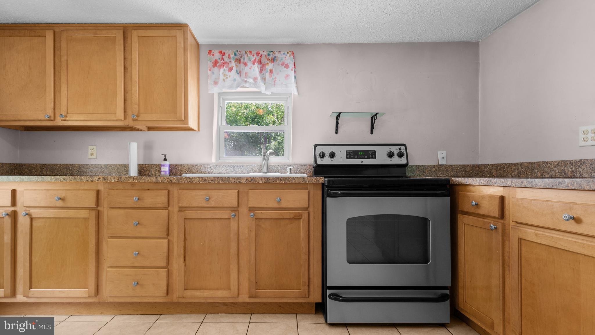 2207 Floral Park Road Clinton, MD 20735 - Photo 10 of 46 a kitchen with granite countertop a sink stove and cabinets