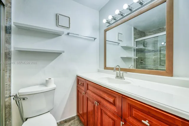 a bathroom with a sink a toilet and a mirror