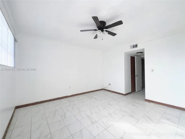 a view of a livingroom with a ceiling fan and window