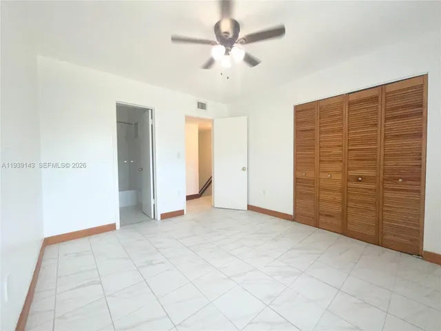 an empty room with closet and ceiling fan