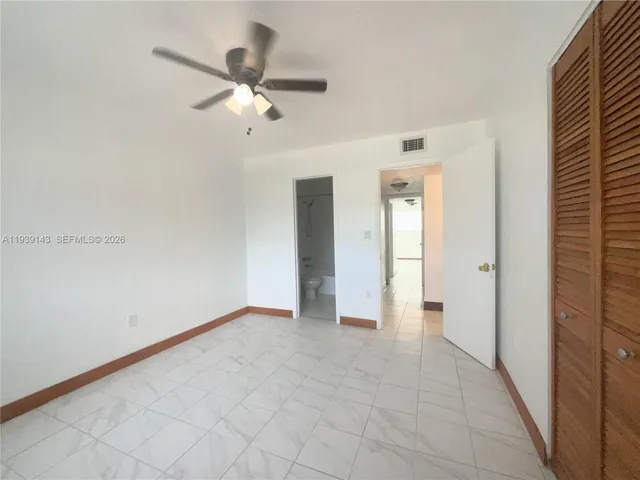 a view of an empty room and chandelier fan