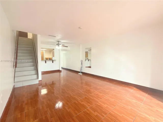 a view of a livingroom with wooden floor and staircase