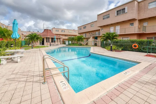 a view of a white building with a swimming pool