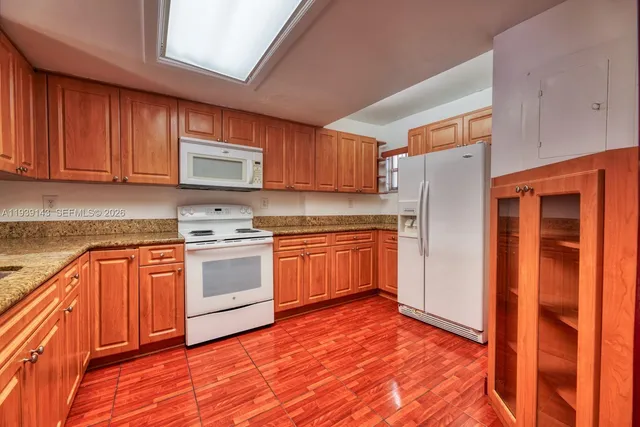 a kitchen with stainless steel appliances granite countertop a refrigerator and a stove top oven