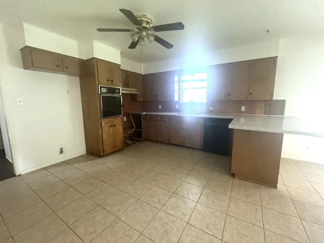 a kitchen with stainless steel appliances a refrigerator a sink a stove top oven a counter space and cabinets