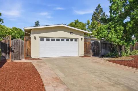 a view of a house with a yard and wooden fence
