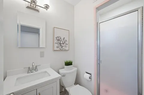 a bathroom with a sink mirror vanity and toilet