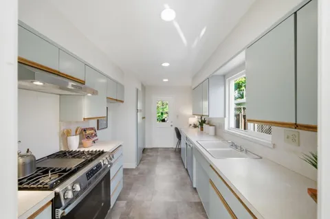 a large kitchen with a stove and a sink