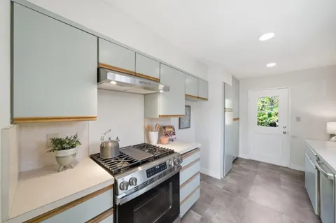 a kitchen with stainless steel appliances granite countertop a stove and a refrigerator