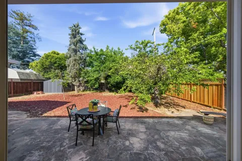 a backyard of a house with table and chairs