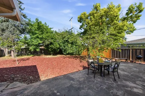 a view of a backyard with table and chairs and potted plants