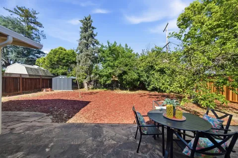 a backyard of a house with table and chairs