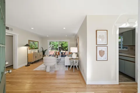 a living room with furniture a refrigerator and kitchen view