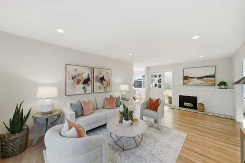 a living room with furniture a fireplace and a wooden floor
