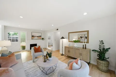 a living room with furniture kitchen view and a potted plant